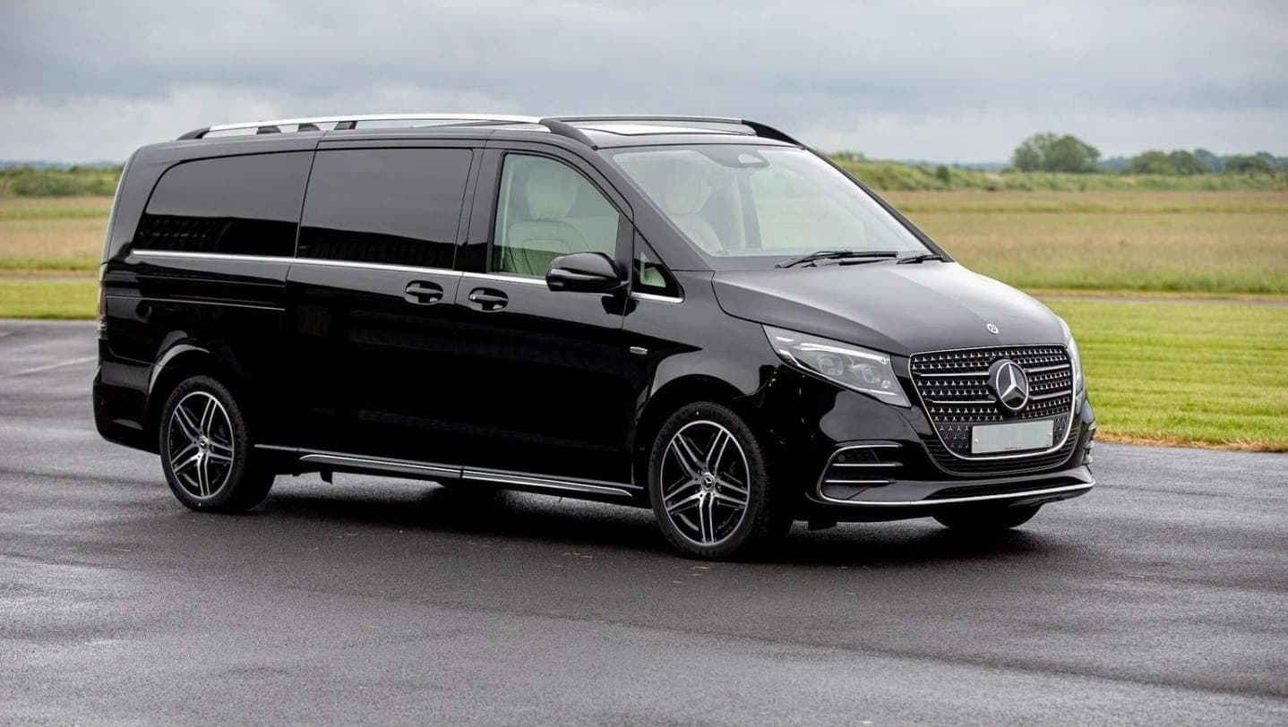 Black Mercedes-Benz V-Class with cream leather seats, parked on open tarmac